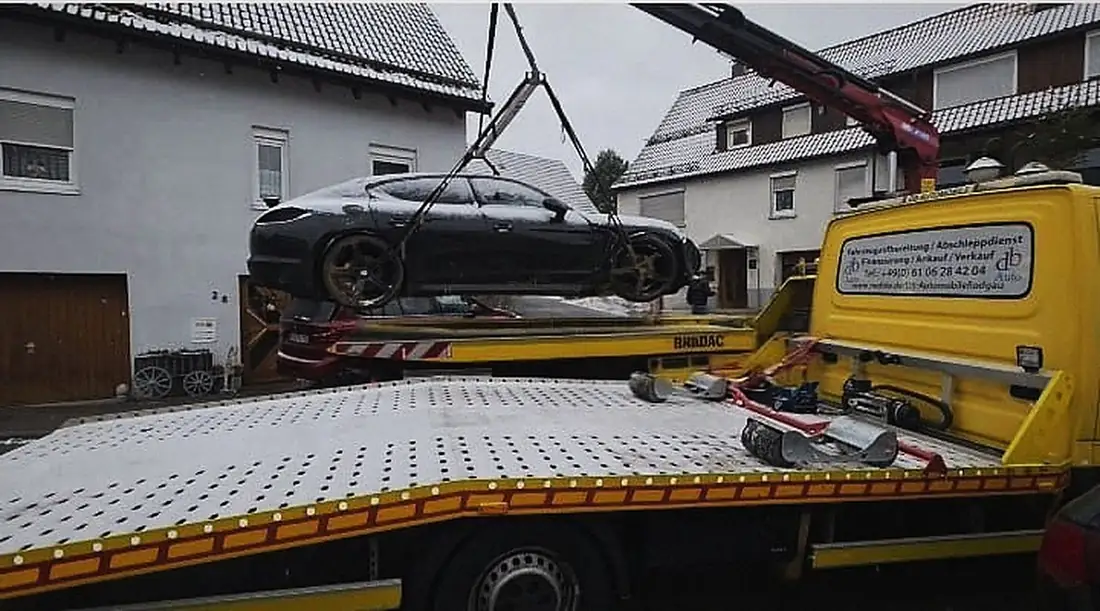 Ein Sportwagen wird per Kran auf das Plateau gehoben